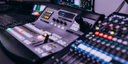 Broadcast production control desk with faders and monitors