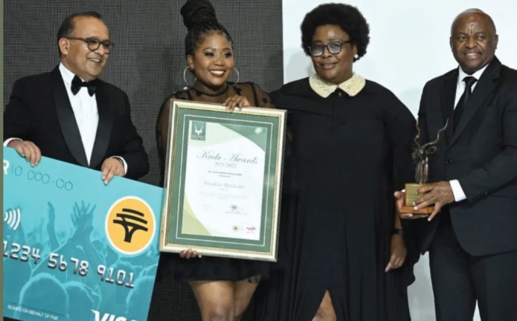 Silindelo Sebata receiving an award on stage alongside industry leaders