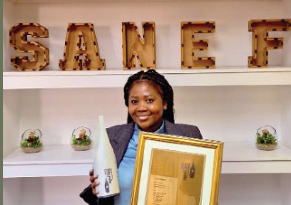 Silindelo Sebata holding a SANEF award and framed certificate