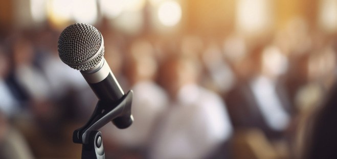 Microphone on stage in front of a seated audience